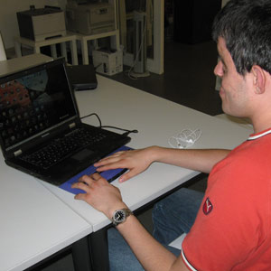 Eine blinde Person, vor dem Computer sitzend