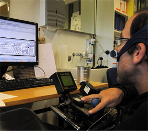 Foto einer Person, die mit einem Joystick auf einer Bildschirmtastatur schreibt.